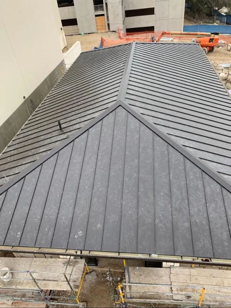 Commercial metal roof construction with crane equipment in Dundee